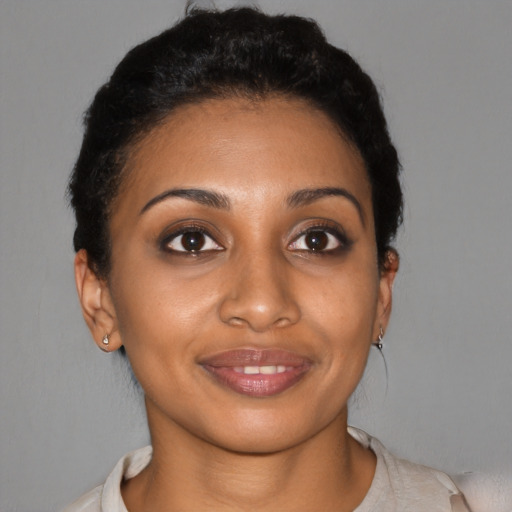 Joyful black young-adult female with short  brown hair and brown eyes