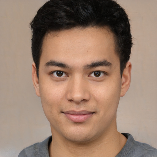 Joyful latino young-adult male with short  black hair and brown eyes