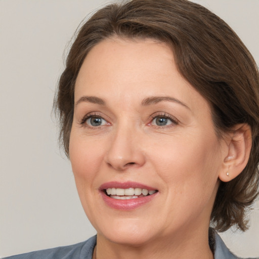 Joyful white adult female with medium  brown hair and brown eyes