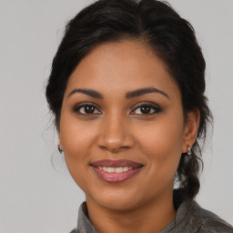 Joyful latino young-adult female with medium  brown hair and brown eyes