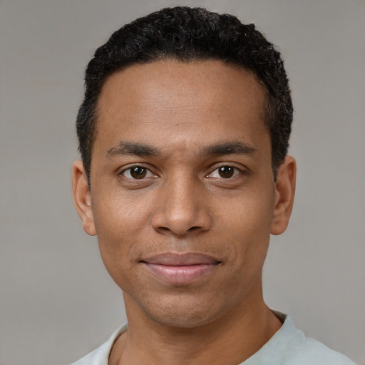 Joyful black young-adult male with short  black hair and brown eyes