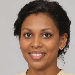 Joyful black adult female with long  brown hair and brown eyes