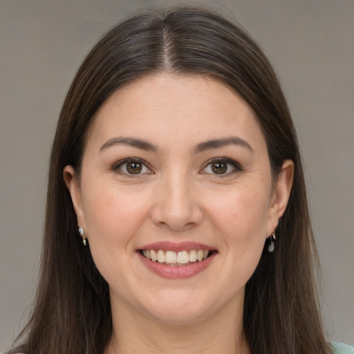 Joyful white young-adult female with long  brown hair and brown eyes