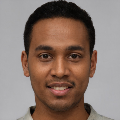 Joyful black young-adult male with short  black hair and brown eyes