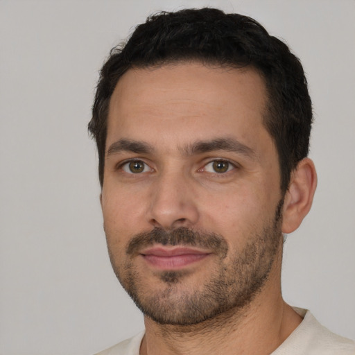 Joyful white young-adult male with short  black hair and brown eyes