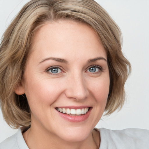 Joyful white young-adult female with medium  brown hair and blue eyes