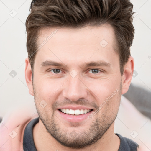 Joyful white young-adult male with short  brown hair and grey eyes