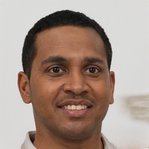 Joyful black young-adult male with short  black hair and brown eyes