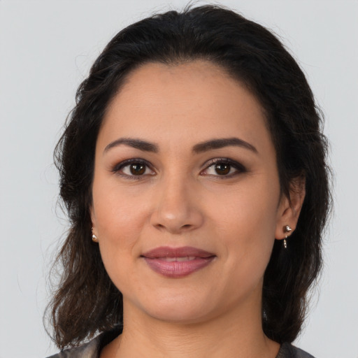 Joyful latino young-adult female with medium  brown hair and brown eyes