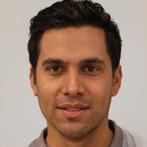 Joyful white young-adult male with short  black hair and brown eyes