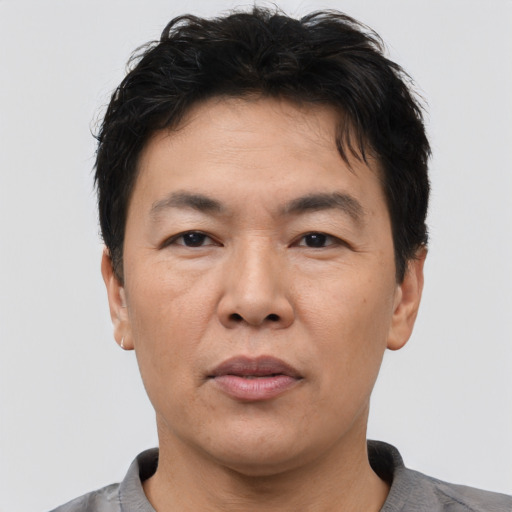 Joyful asian adult male with short  brown hair and brown eyes