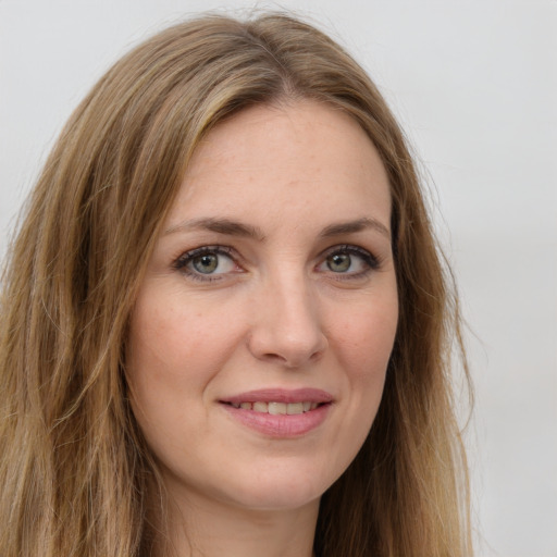 Joyful white young-adult female with long  brown hair and green eyes