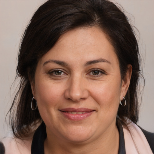 Joyful white adult female with medium  brown hair and brown eyes