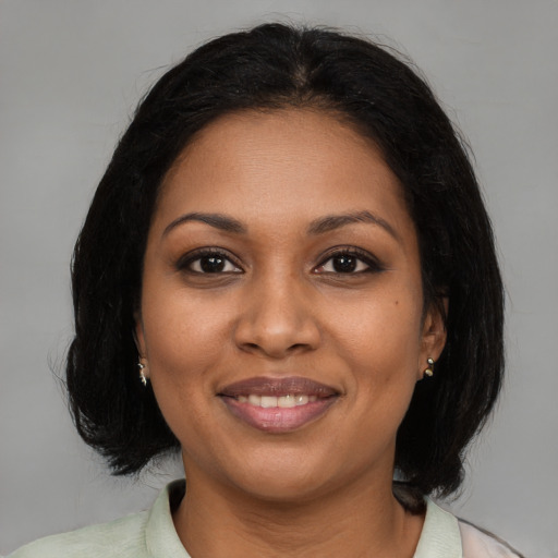 Joyful black young-adult female with medium  brown hair and brown eyes
