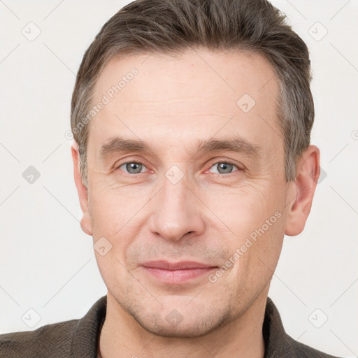 Joyful white adult male with short  brown hair and grey eyes