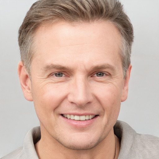 Joyful white adult male with short  brown hair and grey eyes