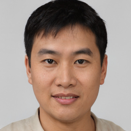Joyful asian young-adult male with short  black hair and brown eyes