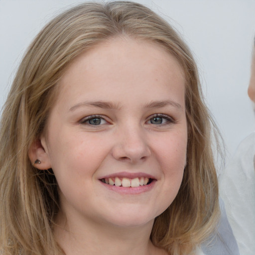 Joyful white child female with long  brown hair and grey eyes