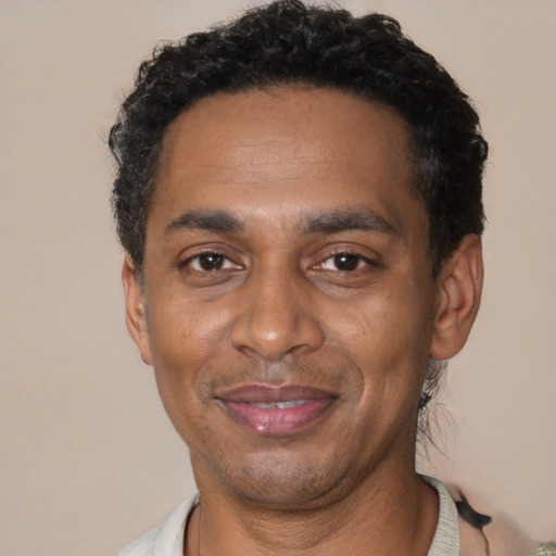Joyful black adult male with short  black hair and brown eyes