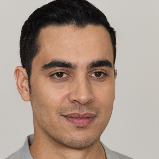 Joyful white young-adult male with short  black hair and brown eyes