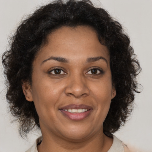 Joyful latino adult female with medium  brown hair and brown eyes