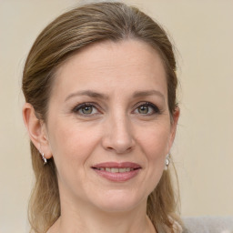 Joyful white adult female with long  brown hair and blue eyes