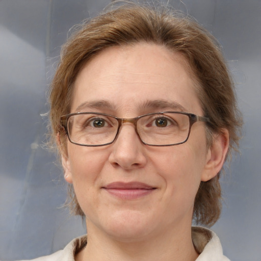 Joyful white adult female with medium  brown hair and blue eyes