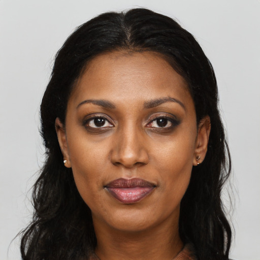 Joyful black young-adult female with long  black hair and brown eyes