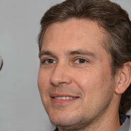 Joyful white adult male with short  brown hair and brown eyes