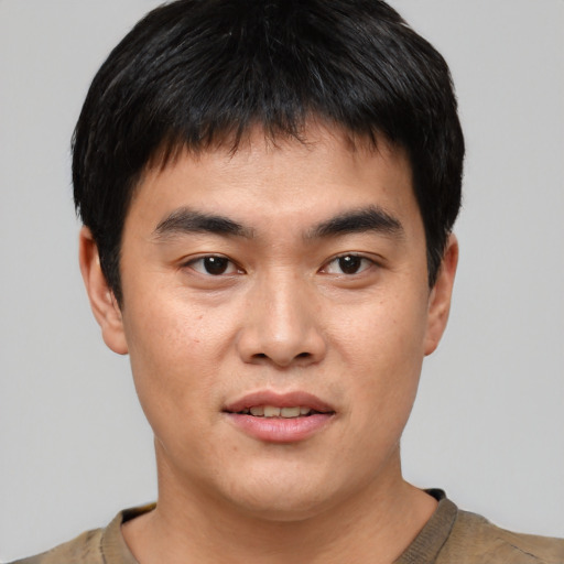 Joyful asian young-adult male with short  black hair and brown eyes