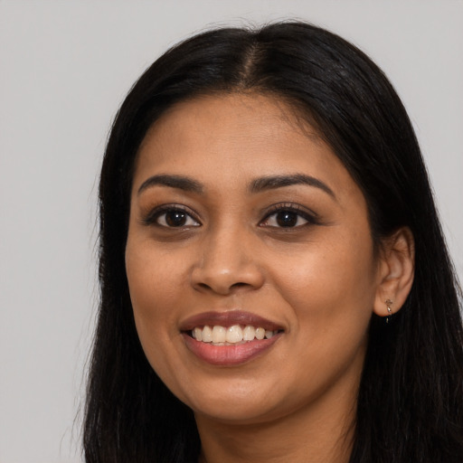 Joyful latino young-adult female with long  black hair and brown eyes