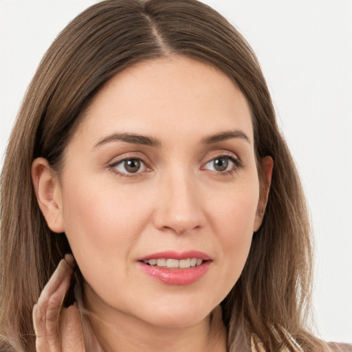 Joyful white young-adult female with long  brown hair and grey eyes