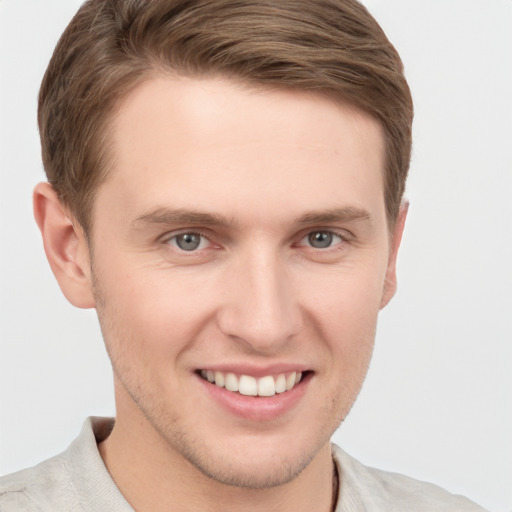 Joyful white young-adult male with short  brown hair and grey eyes