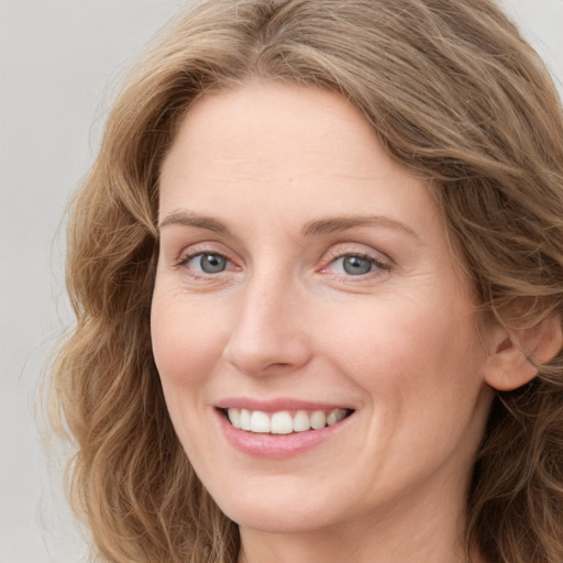 Joyful white young-adult female with long  brown hair and blue eyes