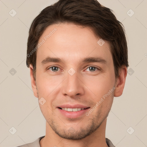 Joyful white young-adult male with short  brown hair and grey eyes