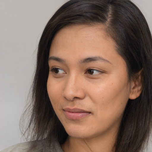 Joyful asian young-adult female with long  brown hair and brown eyes