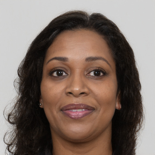 Joyful black adult female with long  brown hair and brown eyes