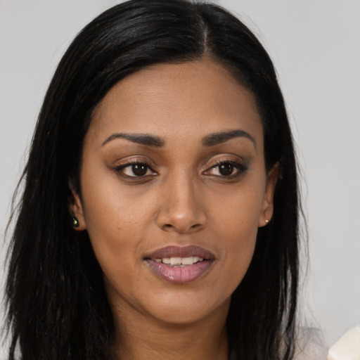 Joyful black young-adult female with long  brown hair and brown eyes