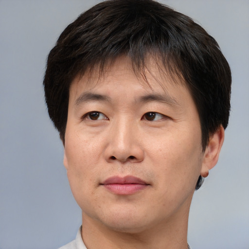 Joyful asian adult male with short  brown hair and brown eyes
