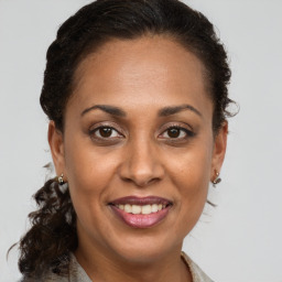 Joyful black adult female with long  brown hair and brown eyes