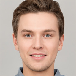 Joyful white young-adult male with short  brown hair and grey eyes