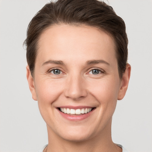 Joyful white young-adult female with short  brown hair and grey eyes