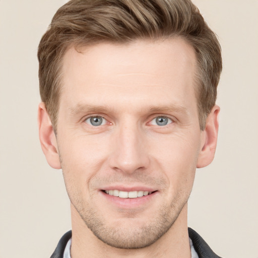 Joyful white young-adult male with short  brown hair and grey eyes