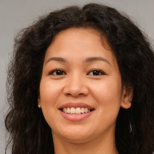 Joyful asian young-adult female with long  brown hair and brown eyes