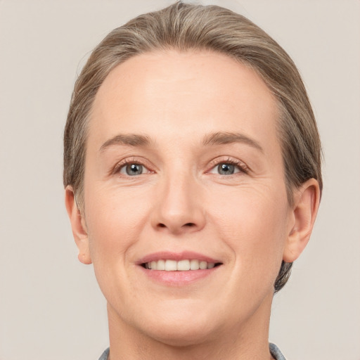 Joyful white adult female with medium  brown hair and grey eyes