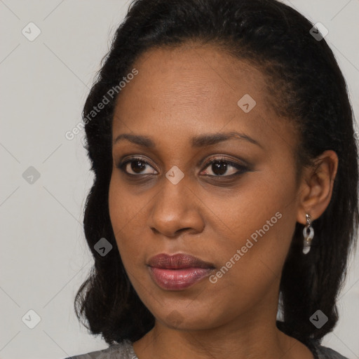 Joyful black young-adult female with long  black hair and brown eyes