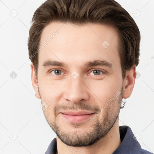 Joyful white young-adult male with short  brown hair and grey eyes