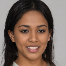 Joyful latino young-adult female with long  brown hair and brown eyes