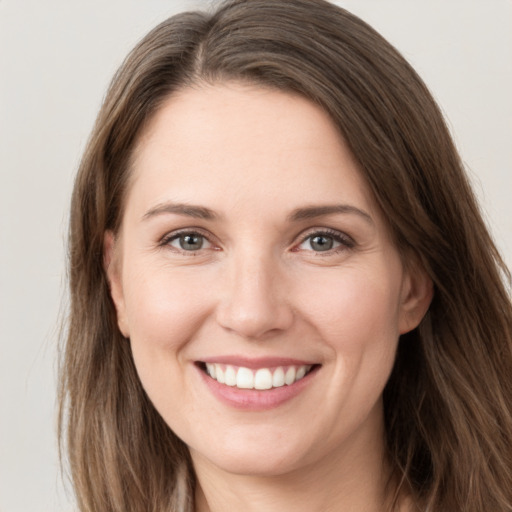 Joyful white young-adult female with long  brown hair and grey eyes