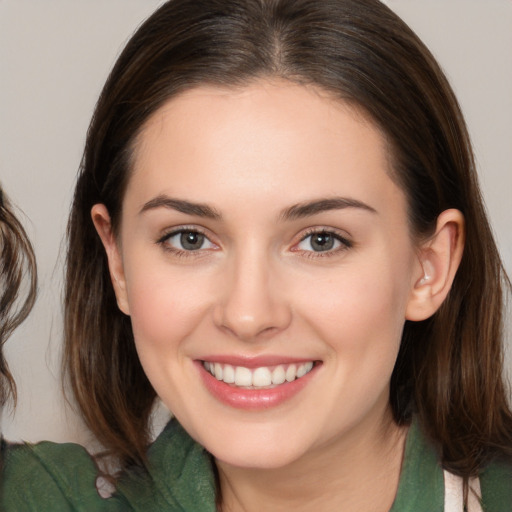 Joyful white young-adult female with medium  brown hair and brown eyes